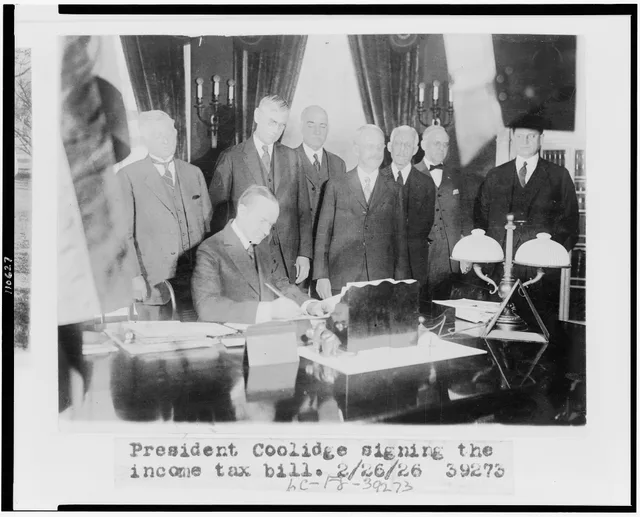 Title: Calvin Coolidge signing the income tax bill, also known as the Mellon tax bill. Secretary of the Treasury Andrew Mellon is the third figure from the right, and Director of the Budget, General Herbert Mayhew Lord, is to Mellon's left Abstract/medium: 1 photographic print. Federal business tax obligations and filing basics
