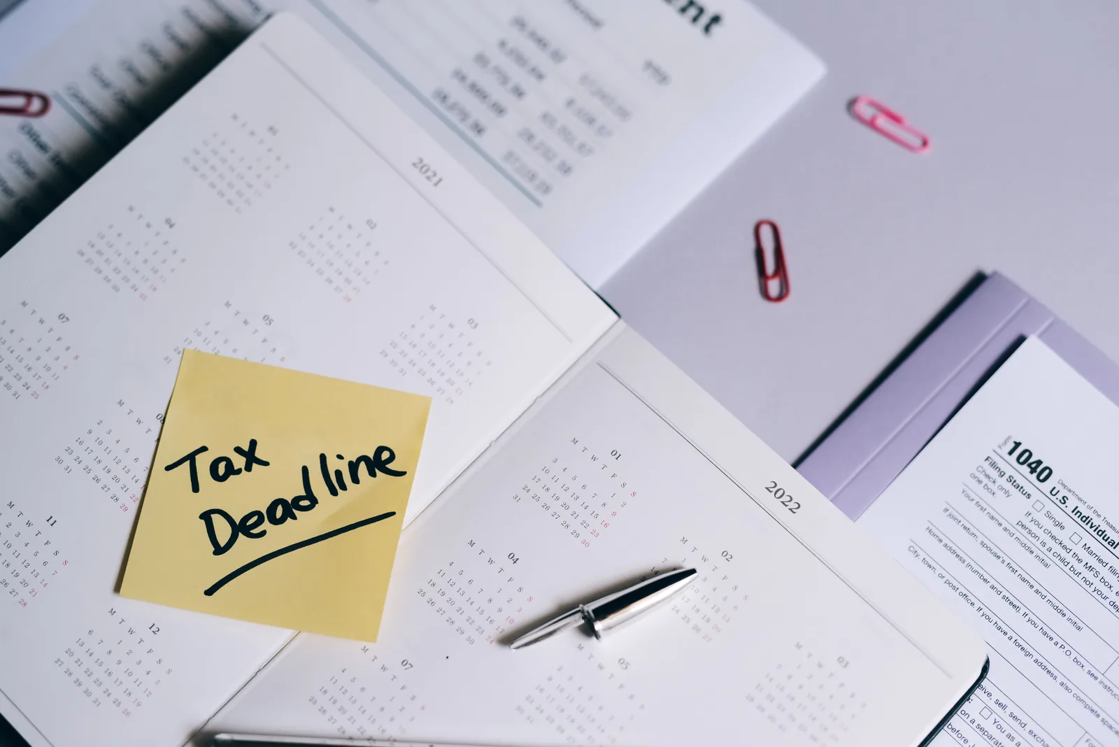 A calendar with a tax deadline note and tax forms, emphasizing organization. Federal business tax rules: the sections behind a return