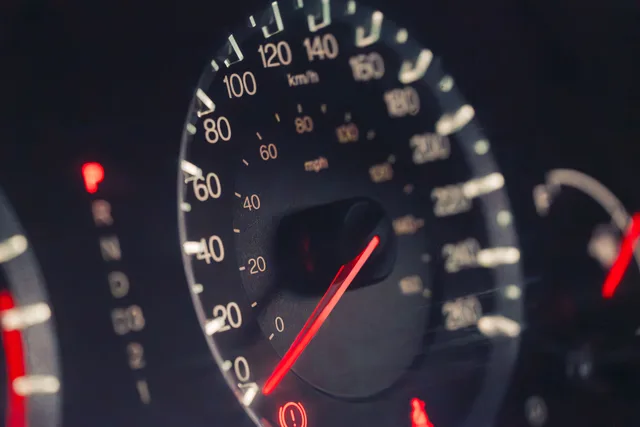 Detailed view of a car speedometer showing km/h and mph in low light settings. Mileage Deduction Records When Two Preparers Split Your Return